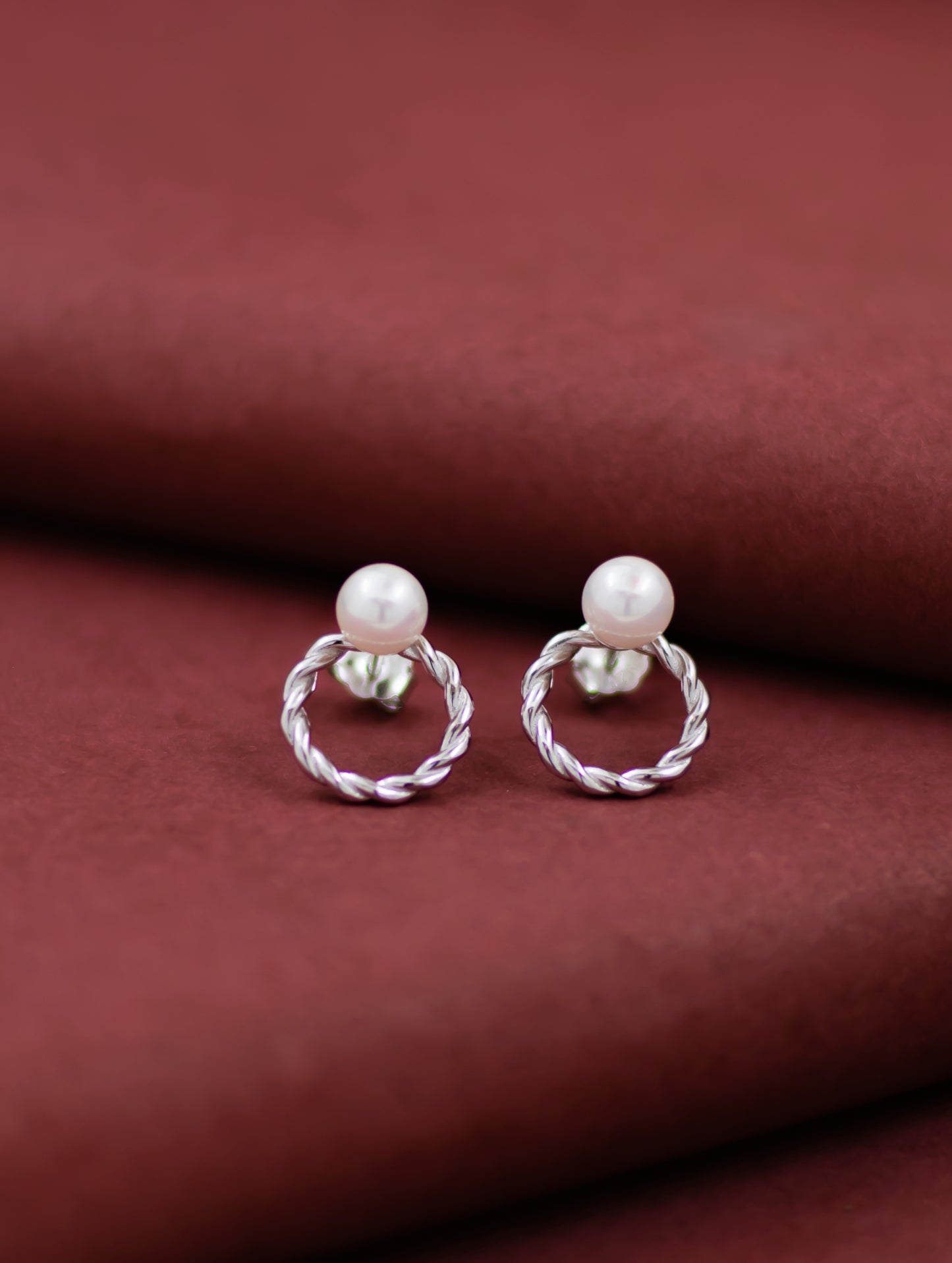 Sterling silver round stud earrings with natural pearl.