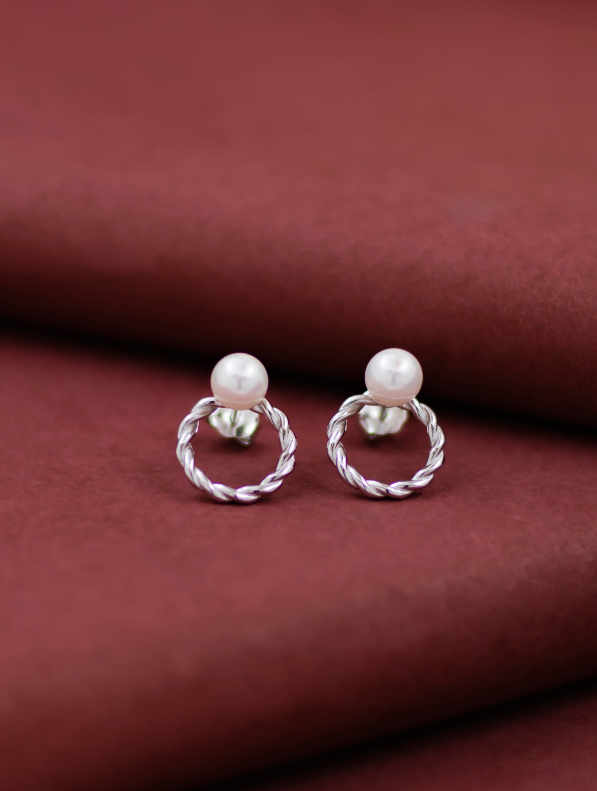 Sterling silver round stud earrings with natural pearl.