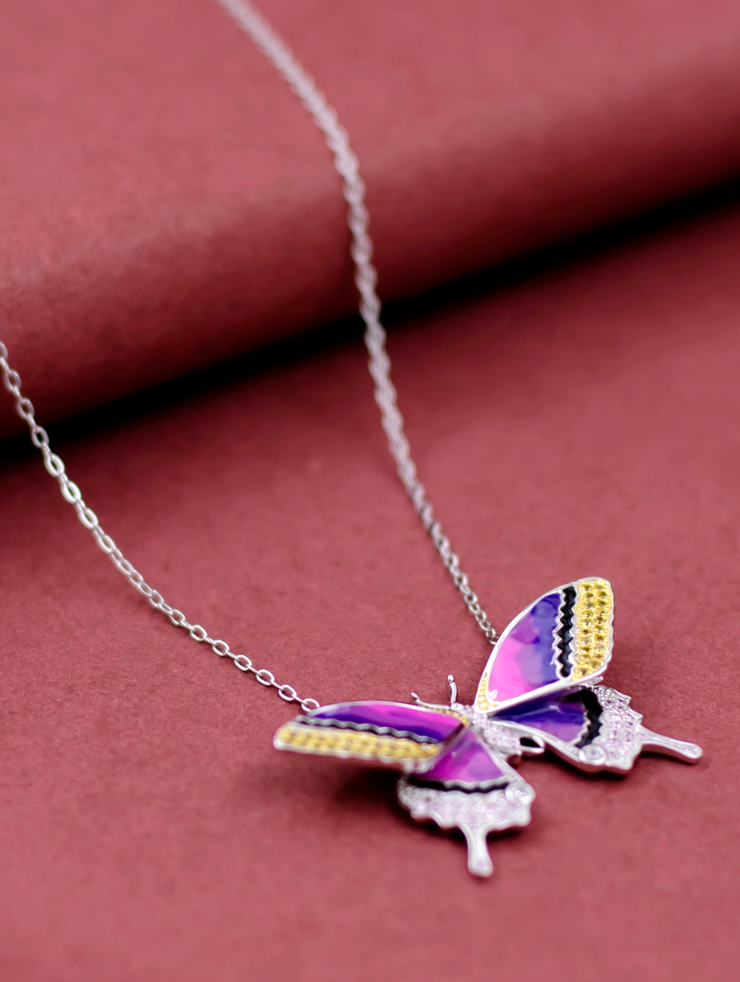 Sterling silver butterfly pendant with coloured Swarovski crystals and enamel detailing.