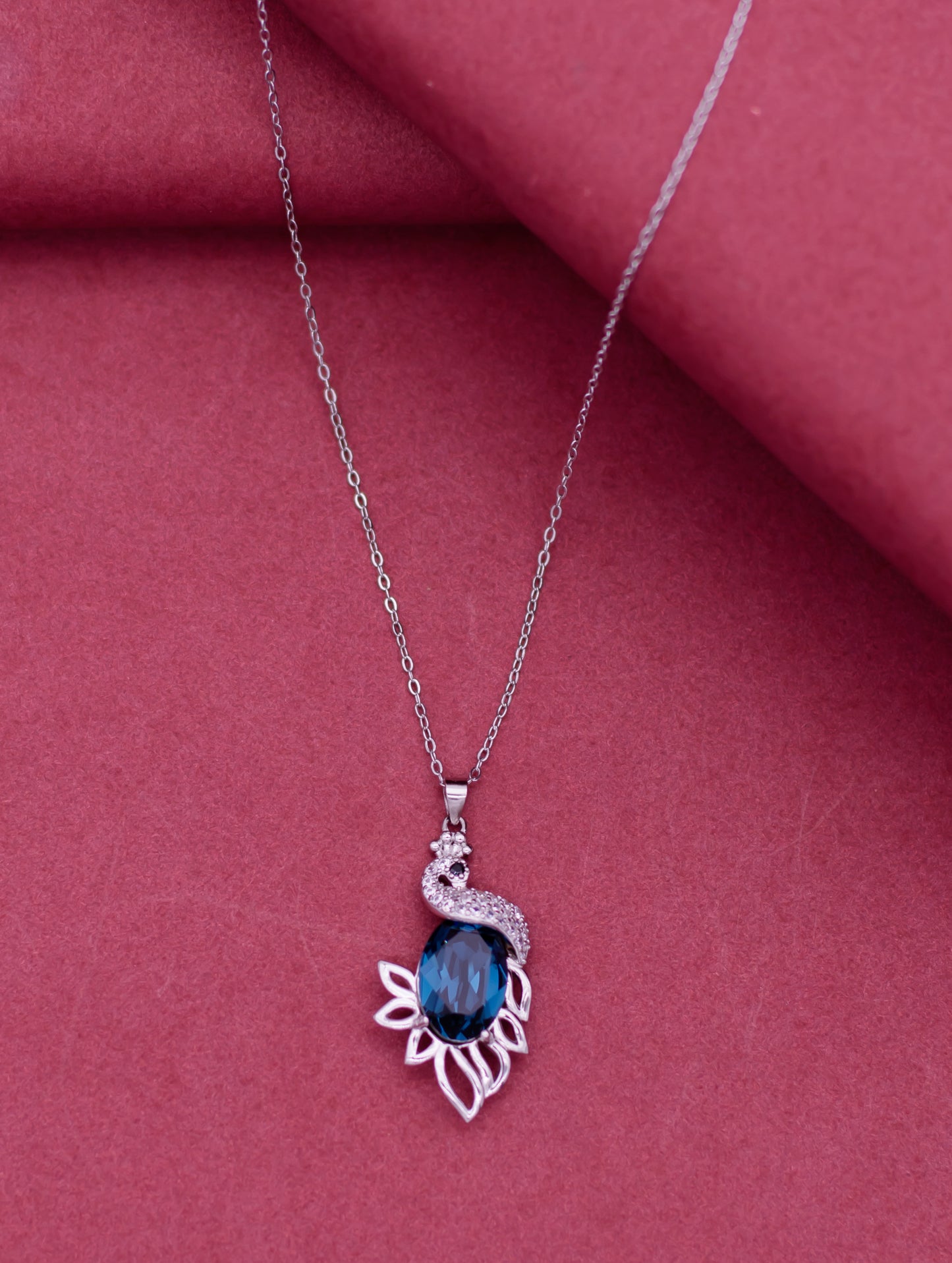 Silver pendant chain adorned with Swarovski zircon and blue gemstone.