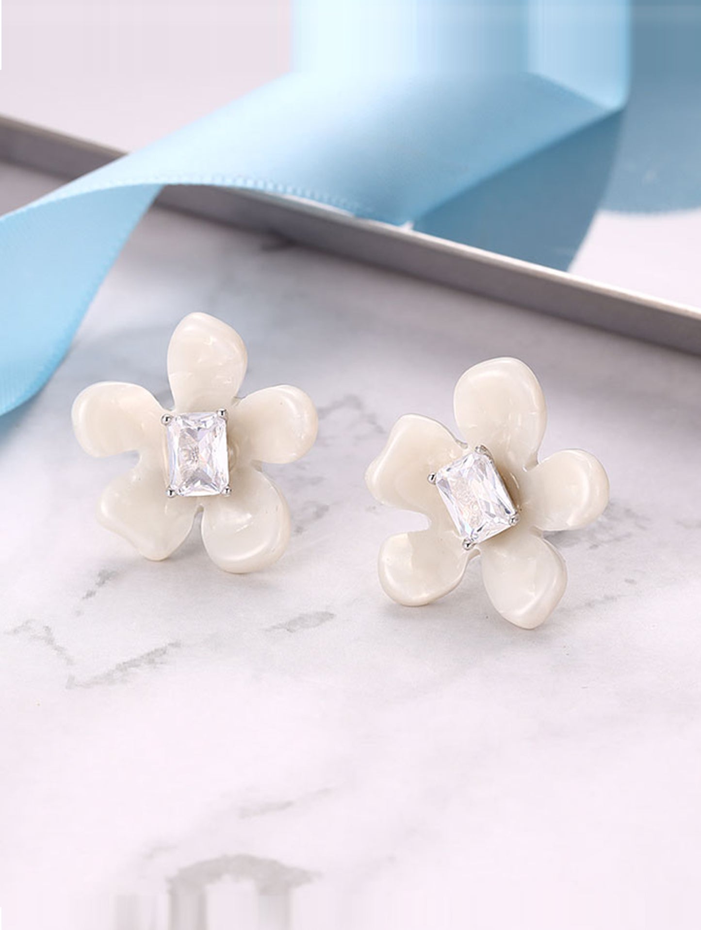 Sterling silver flower-shaped earrings with semi-precious white stones.
