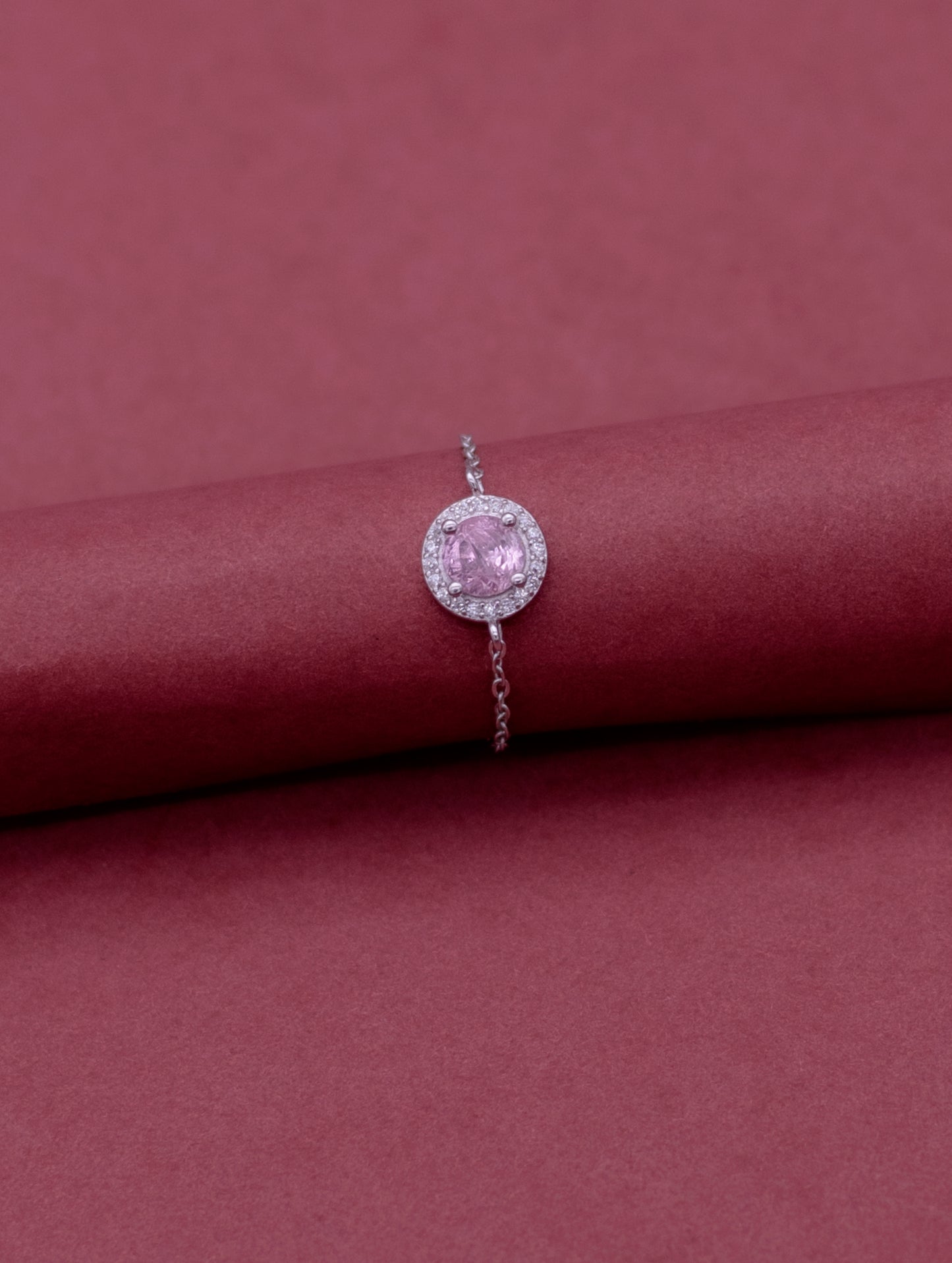 Adjustable sterling silver chain ring with round pink stone and Swarovski zircon accents.