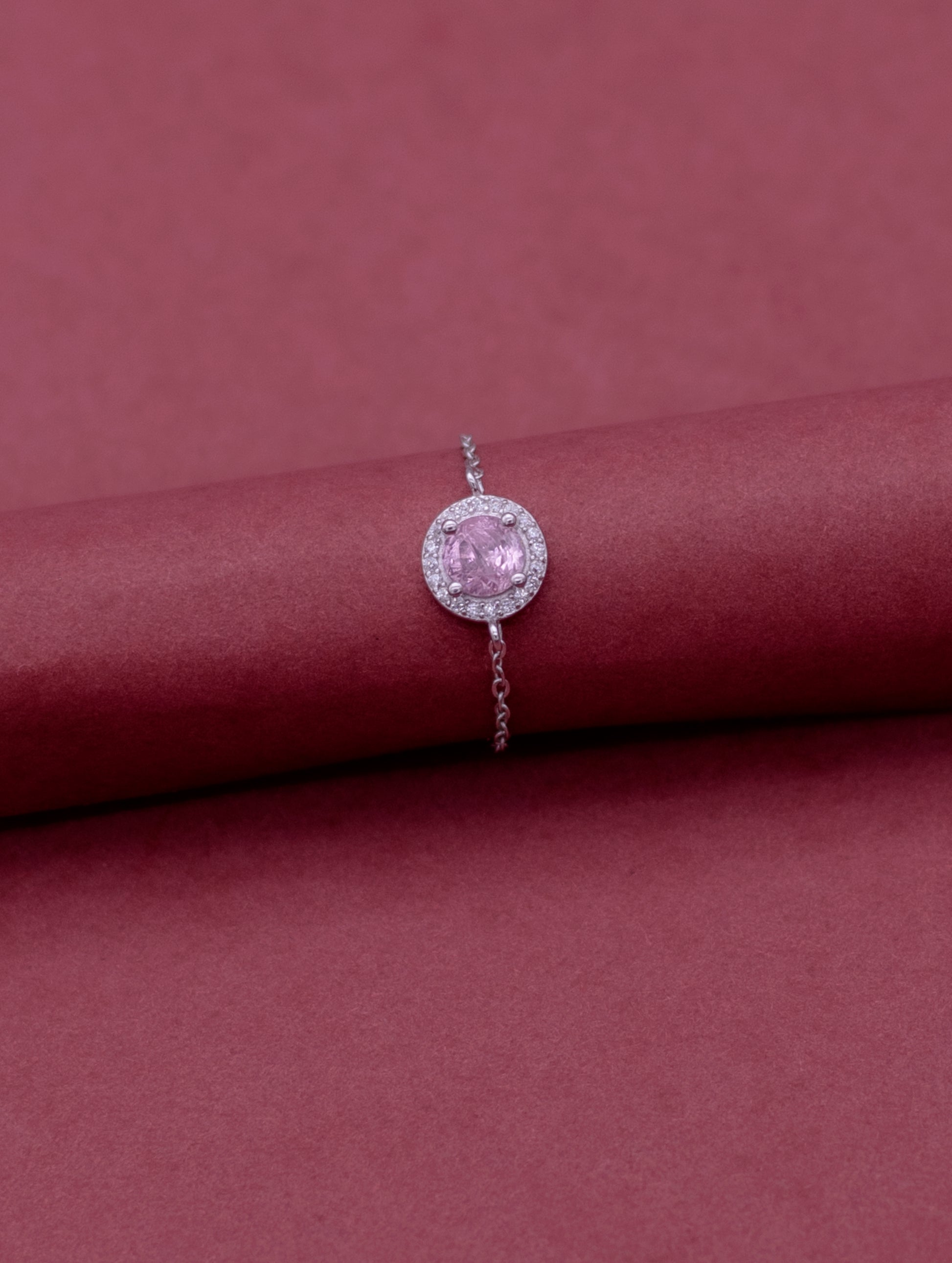 Adjustable sterling silver chain ring with round pink stone and Swarovski zircon accents.
