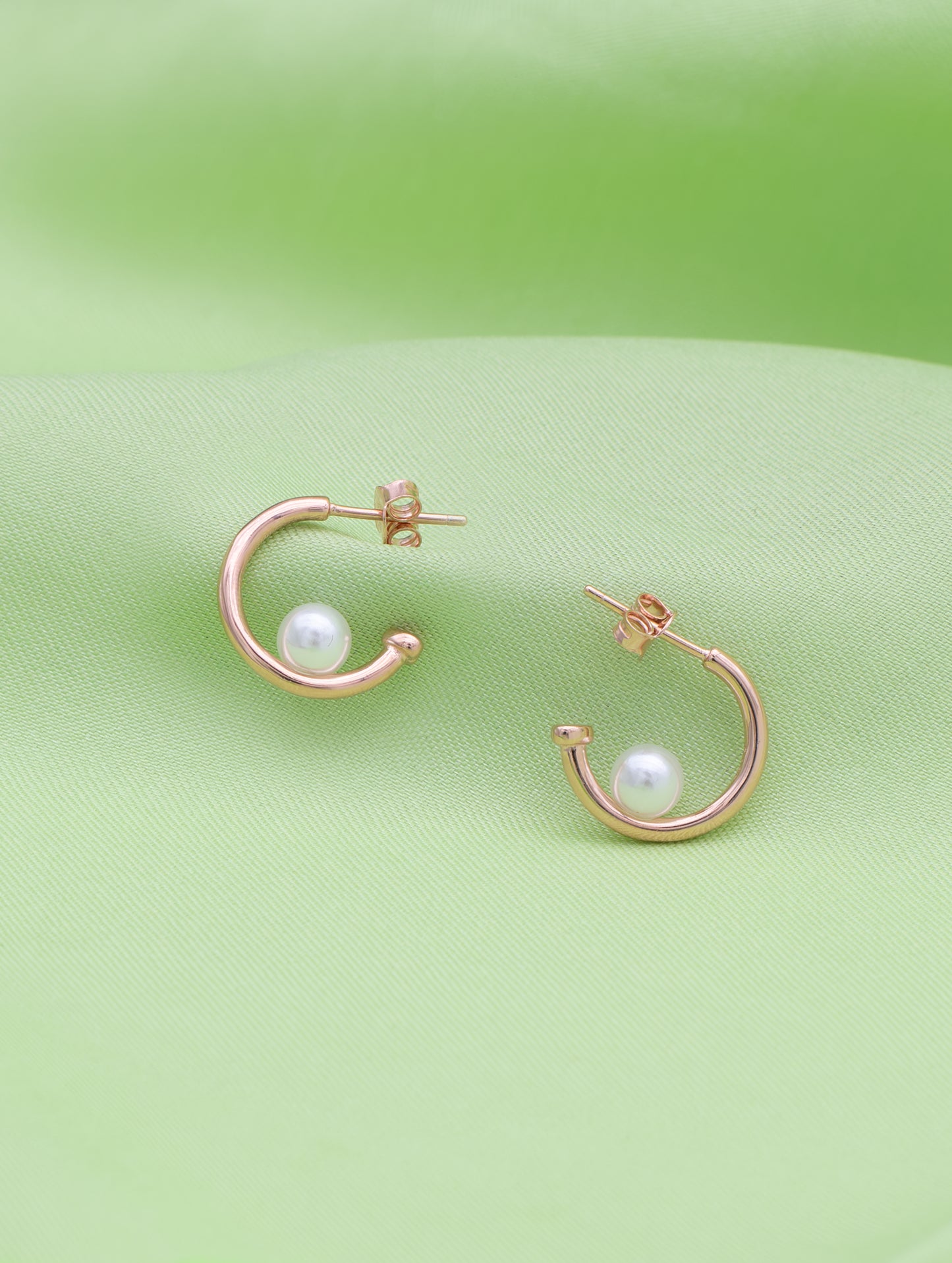 Curve-shaped sterling silver earrings with delicate natural pearl.
