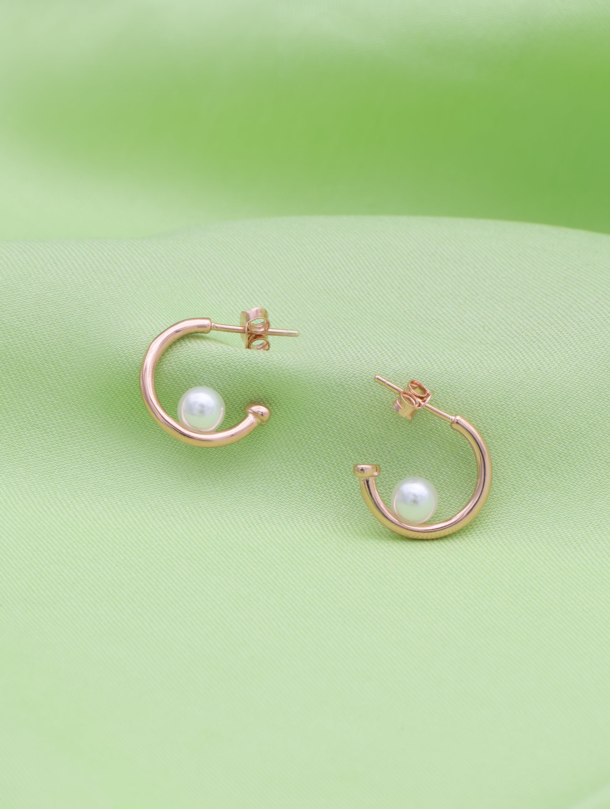 Curve-shaped sterling silver earrings with delicate natural pearl.