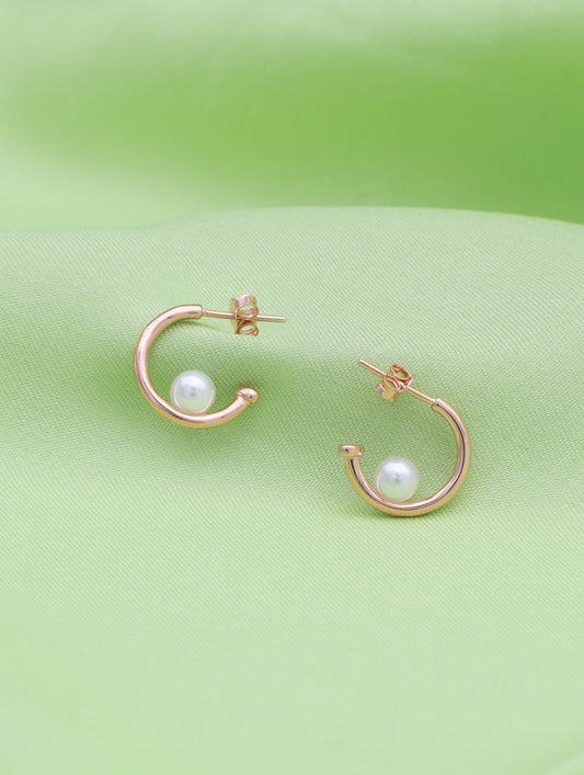 Curve-shaped sterling silver earrings with delicate natural pearl.