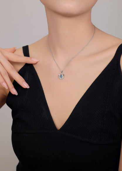 Silver chain featuring heart pendant with semi-precious blue stone.
