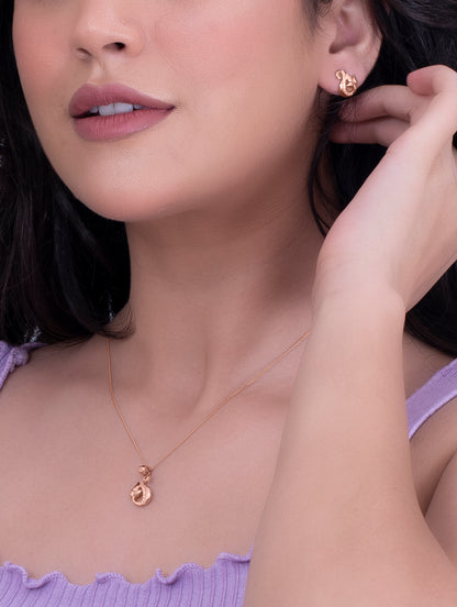 Close-up of a woman wearing a gold necklace and earrings.