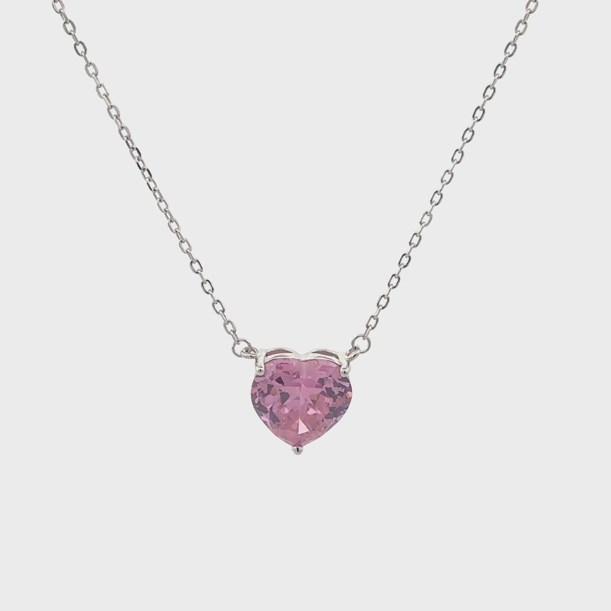 Elegant silver necklace featuring a pink heart-shaped stone.