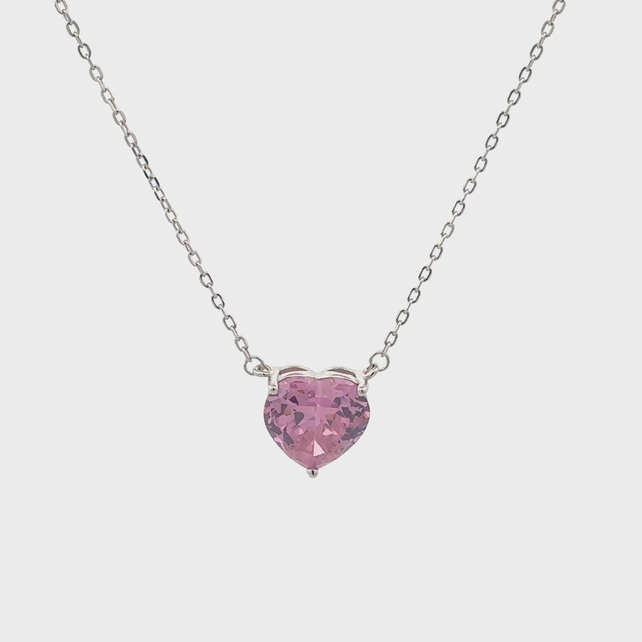 Elegant silver necklace featuring a pink heart-shaped stone.