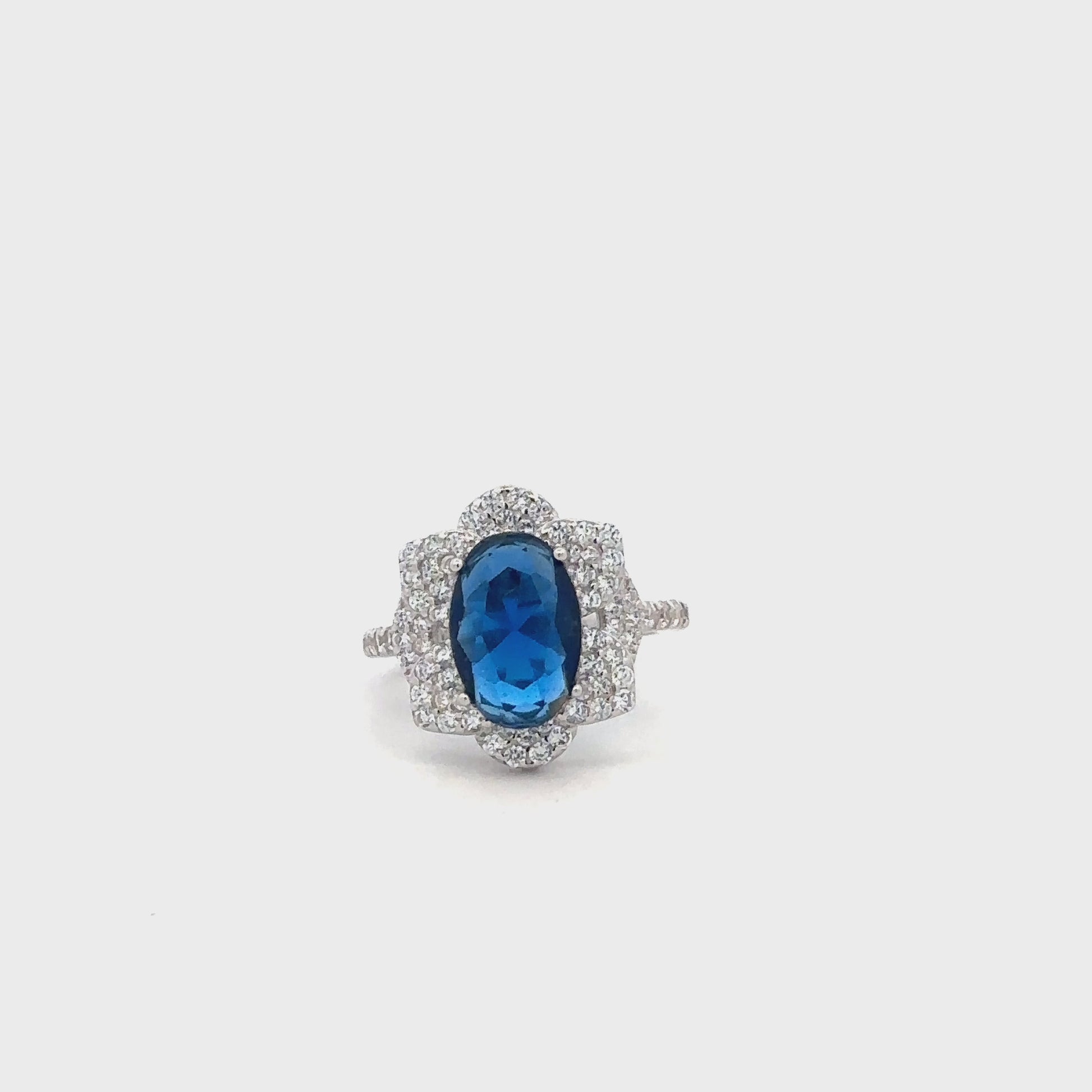 Close-up of silver ring featuring a vibrant blue gemstone and sparkling zircon accents.