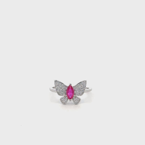 Close-up of sterling silver ring featuring butterfly design with pink accent stone.
