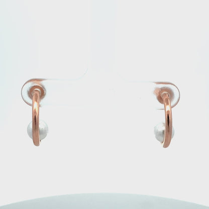 Close-up of sterling silver earrings with natural pearl accent.