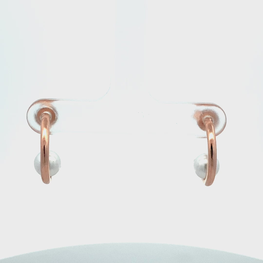 Close-up of sterling silver earrings with natural pearl accent.