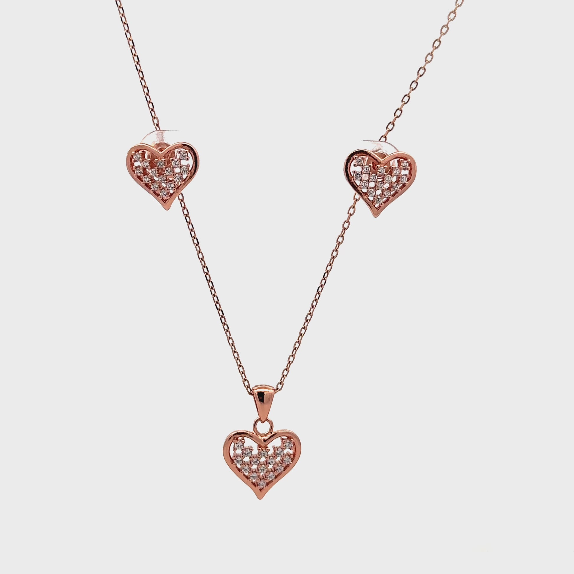 Romantic rose gold pendant and earrings set featuring heart design and polished finish.