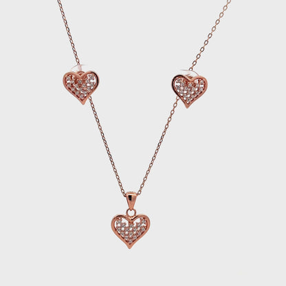 Romantic rose gold pendant and earrings set featuring heart design and polished finish.