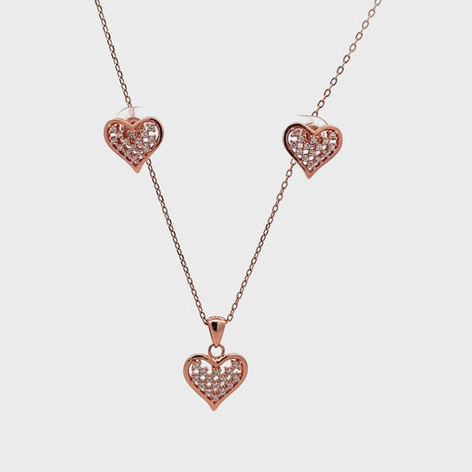 Romantic rose gold pendant and earrings set featuring heart design and polished finish.